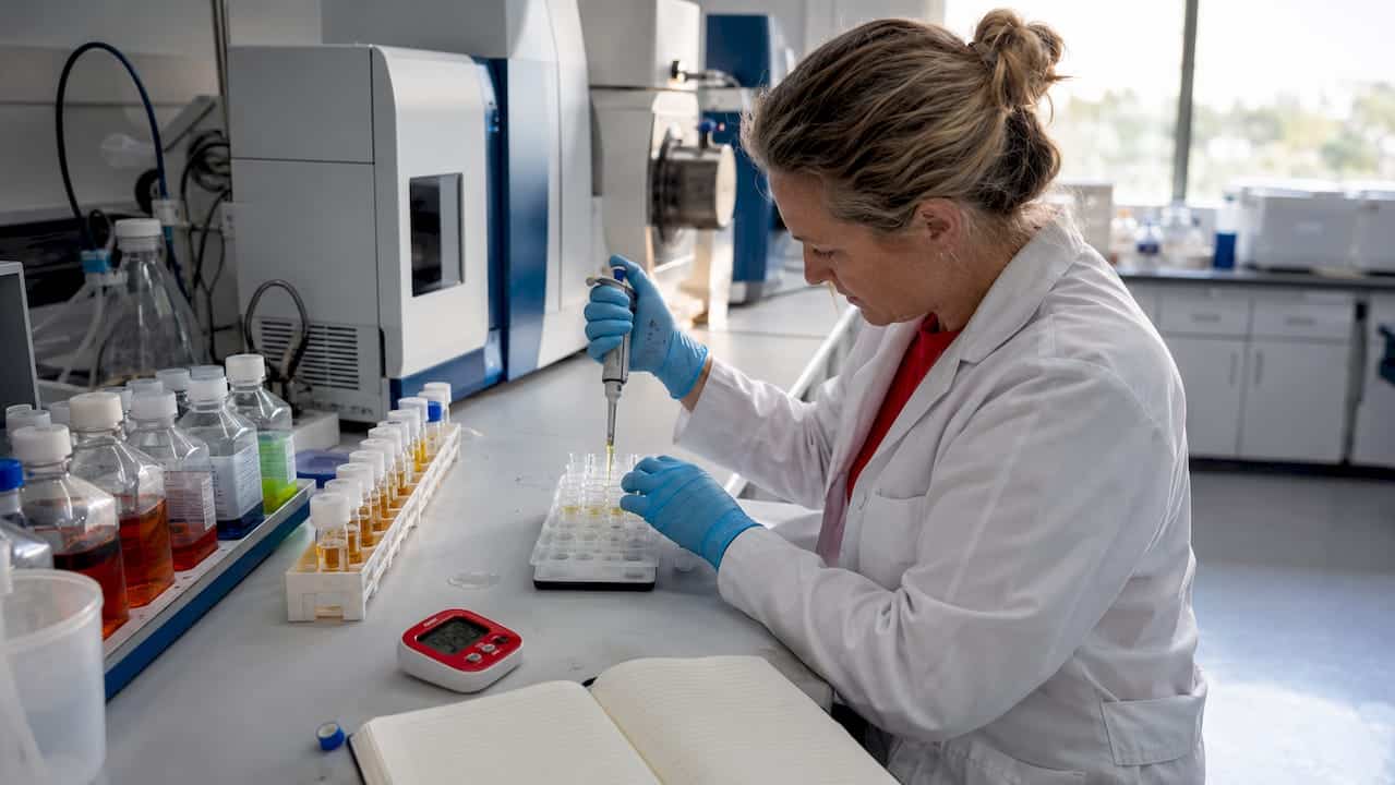 Lab technician handling synthetic drug samples
