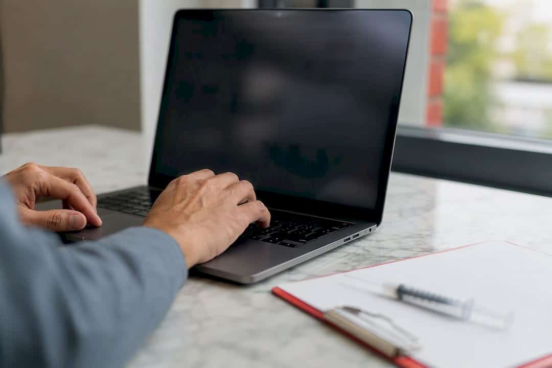 Hands browsing drug test products on laptop