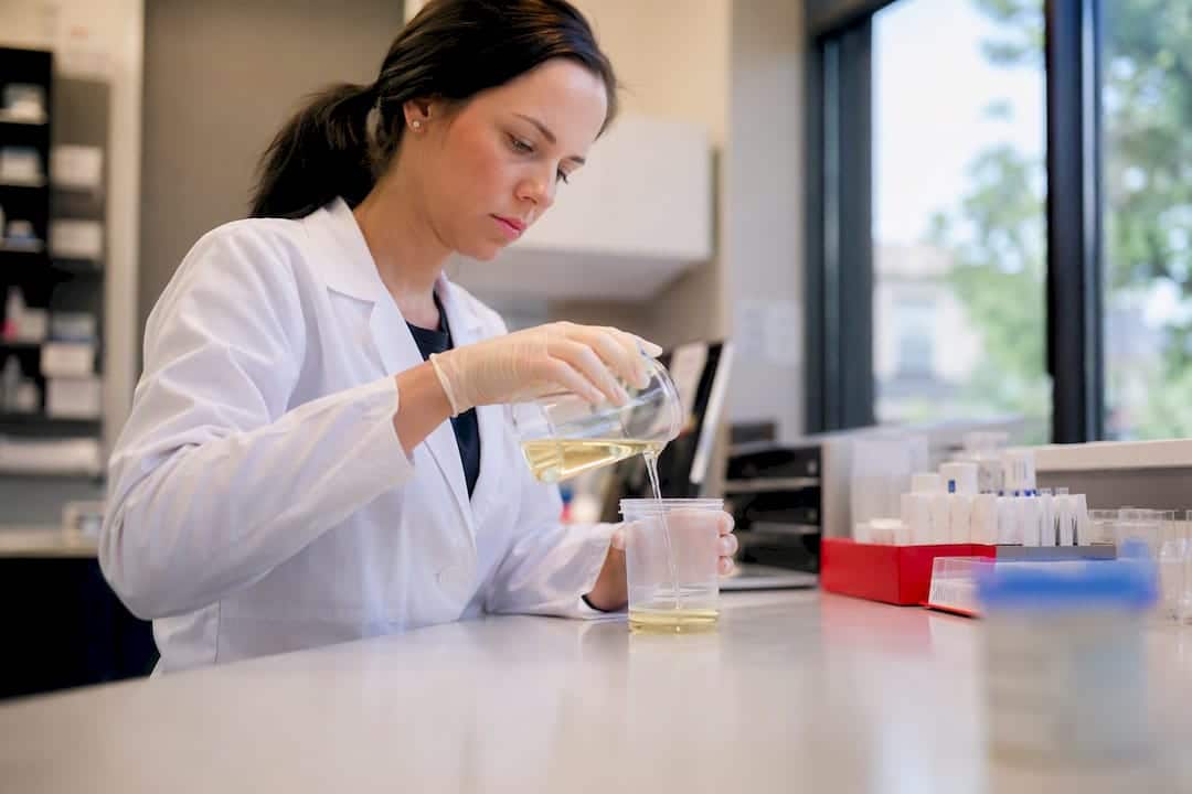 Technician preparing urine sample in drug test cup