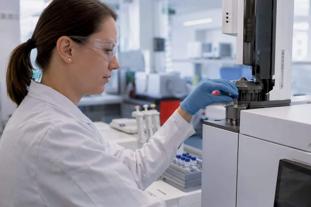 Gloved hand injecting sample into GC-MS instrument