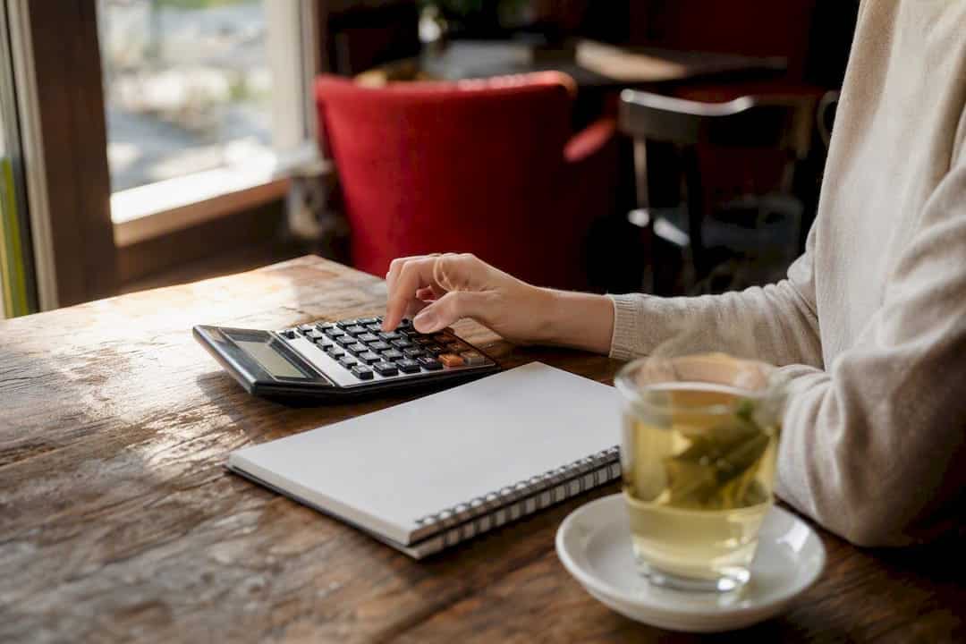 Hands using calculator for budget planning