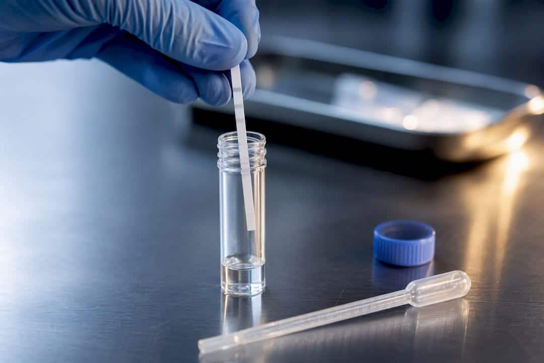 Anonymous test strip entering sample vial