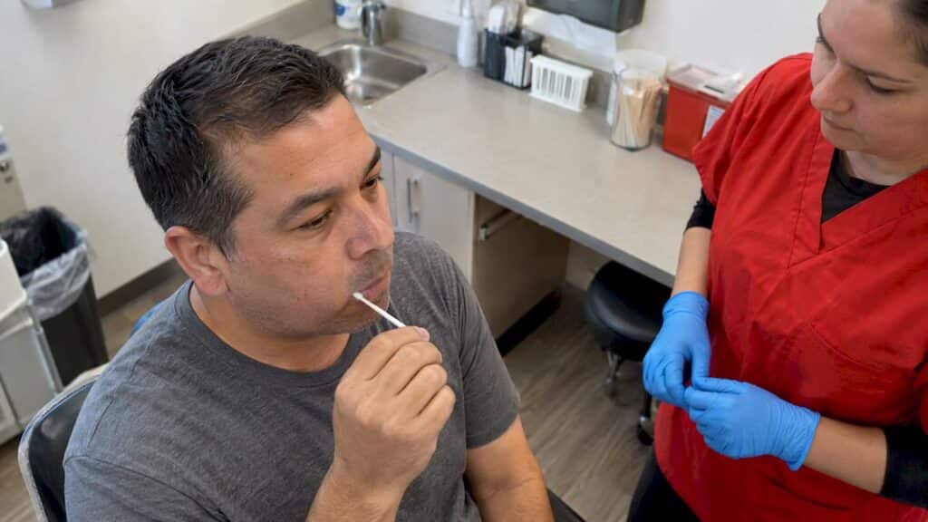 Adult providing an oral fluid sample